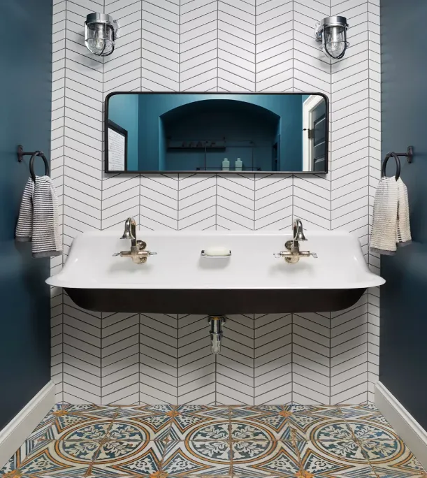 This image may contain; floating sink wall hanging with towels, mirror above sink and patterned tiles