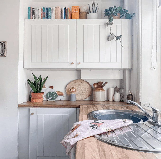 books on white cabinets ,kitchen items on counter top of kitchen,sink