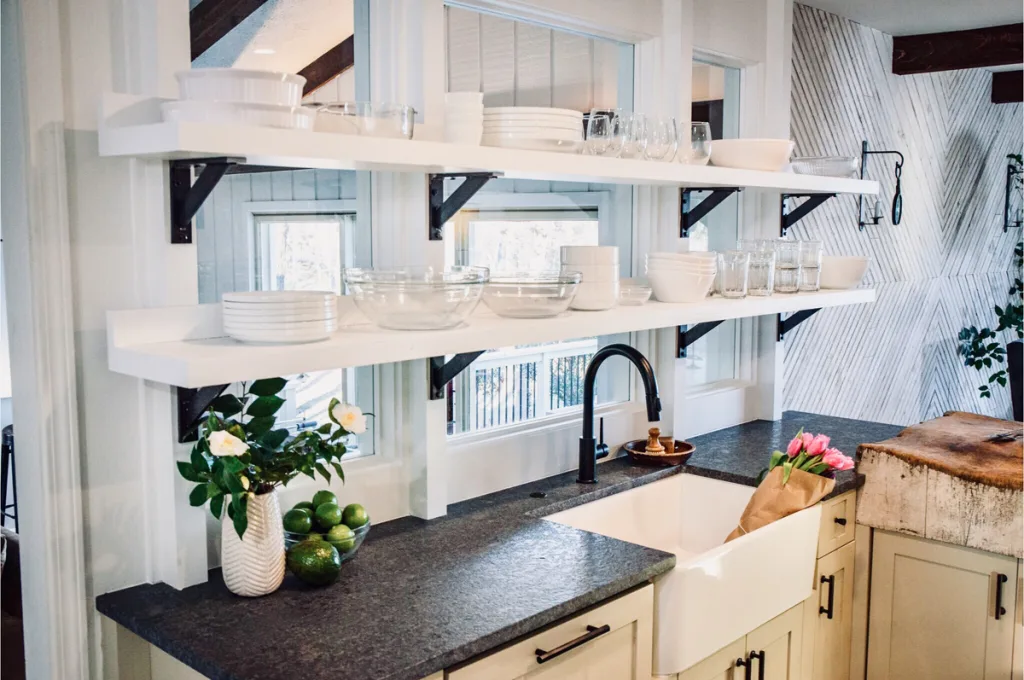 floating shelves over window with table wares above sink