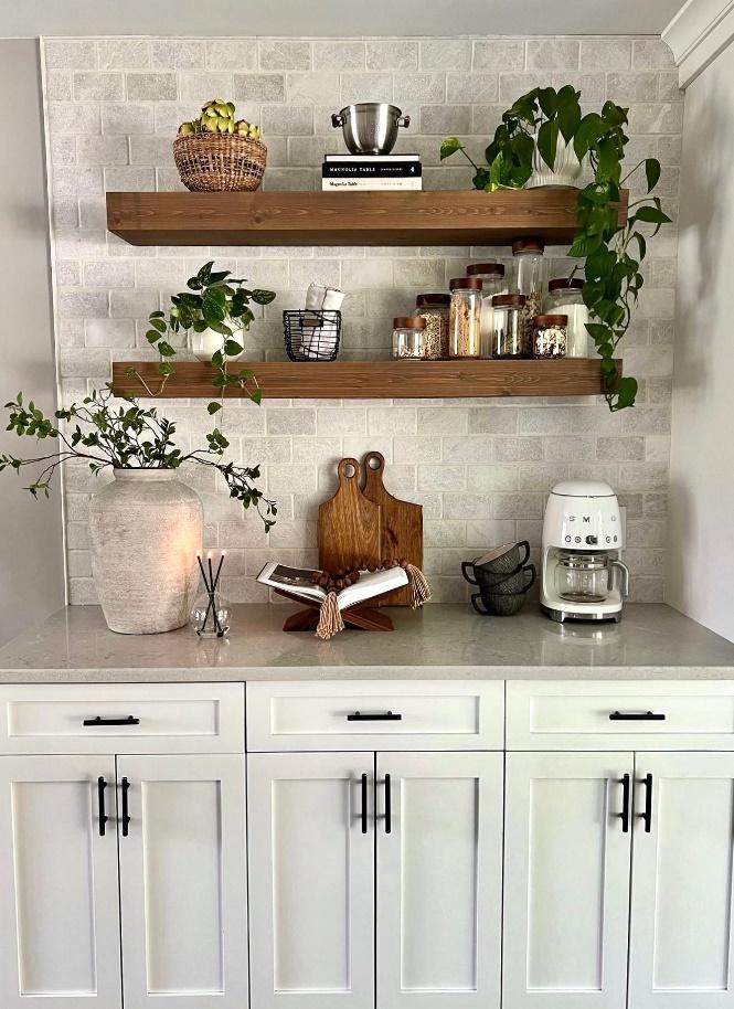 coffee items on floating shelfs above wjite cabinets