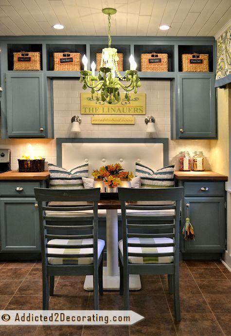 brown accent boxes or storage boxes above the grey cabinets and grey chairs in kitchen