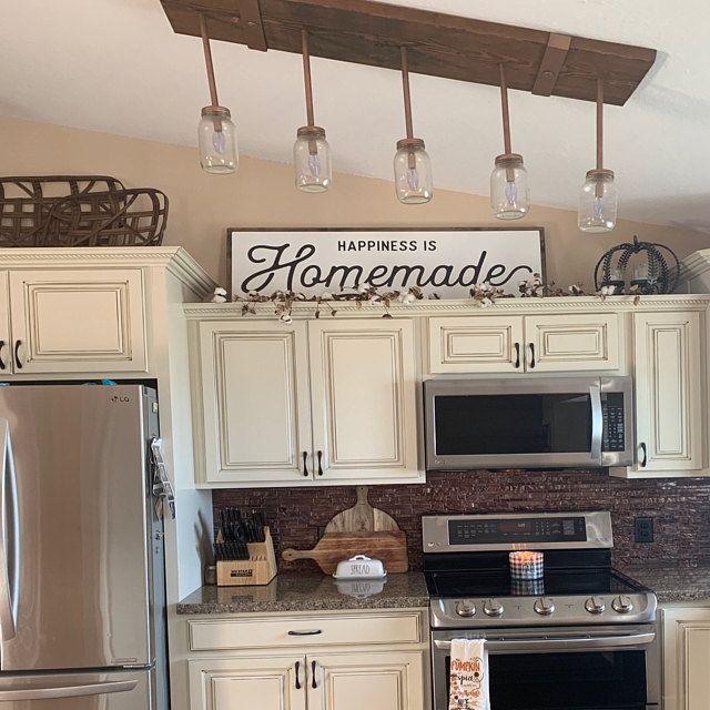 decorative sign above kichen cabinet having brown theme and lights