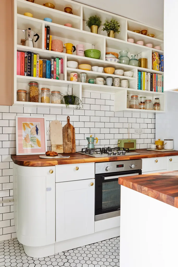 kitchen shelves above the stove having jars storage ,ceremic items, cookbook area, plants and all kitchen items