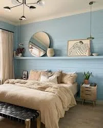 king size bed in small room with shelf mirror, plant and photo frame