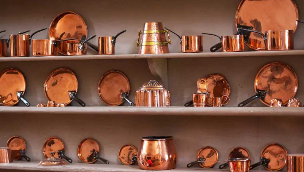 copper utensils on open self